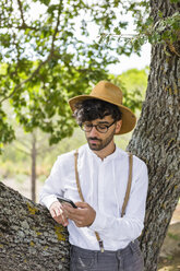 Man wearing old-fashioned clothes using cell phone - MGIF00136