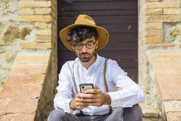 Man wearing old-fashioned clothes using cell phone - MGIF00139