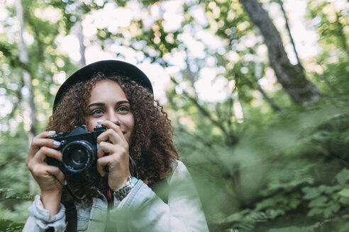 Porträt eines lächelnden Teenagers, der Bilder in der Natur macht - VPIF00095