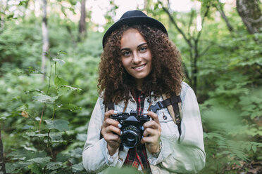 Porträt eines lächelnden Teenagers, der Bilder in der Natur macht - VPIF00096