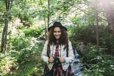 Portrait of smiling teenage girl with camera in nature - VPIF00100