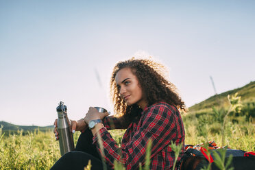 Teenager-Mädchen mit Thermoskanne, das sich in der Natur ausruht - VPIF00106