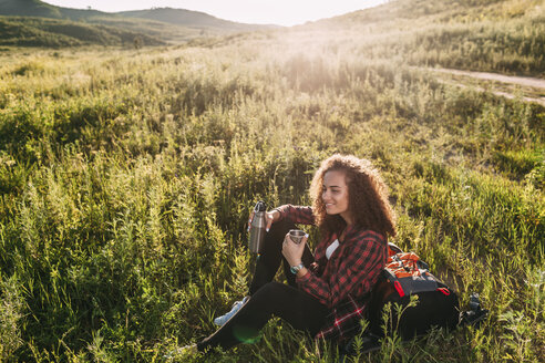 Teenager-Mädchen mit Thermoskanne, das sich in der Natur ausruht - VPIF00107