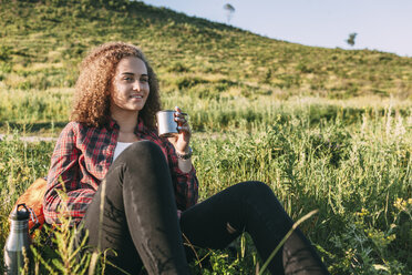 Teenage girl with thermos flask having a rest in nature - VPIF00108