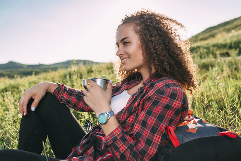 Teenager-Mädchen mit Thermoskanne, das sich in der Natur ausruht - VPIF00109