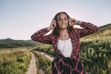 Teenager-Mädchen hört Musik mit Kopfhörern in der Natur - VPIF00112
