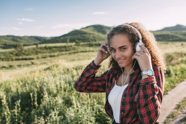 Teenager-Mädchen hört Musik mit Kopfhörern in der Natur - VPIF00114