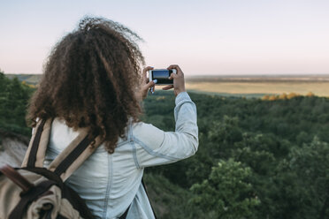 Back view of teenage taking picture of landscape - VPIF00135