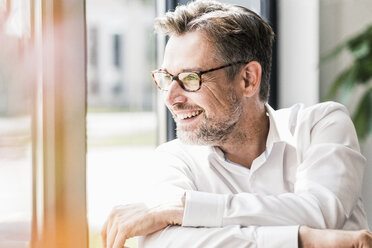 Smiling businessman with glasses looking sideways - UUF11706