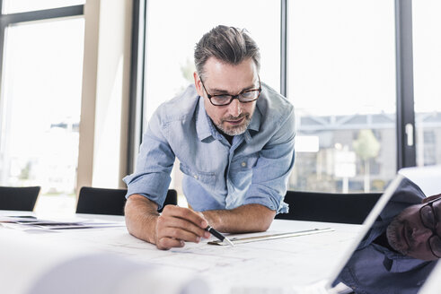 Businessman working at desk in office - UUF11713