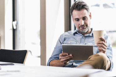 Businessman holding tablet in office - UUF11716