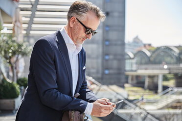 Businessman with sunglasses waiting at the airport - SUF00327