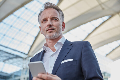 Geschäftsmann mit Smartphone auf dem Flughafen - SUF00333