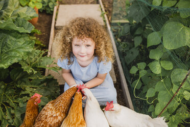 Porträt eines kleinen Mädchens, das Hühner im Kleingarten füttert - NMSF00157