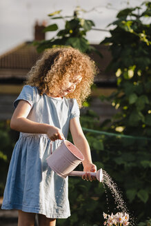 Kleines Mädchen bewässert Blumen im Garten - NMSF00166