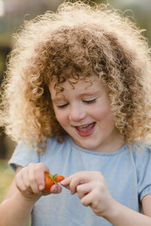Porträt eines lachenden kleinen Mädchens mit Tomate - NMSF00172
