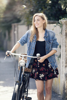 Junge Frau mit Fahrrad in der Stadt - MAEF12420