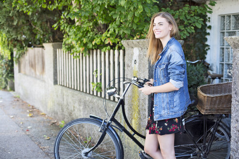 Junge Frau mit Fahrrad in der Stadt - MAEF12440