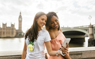 UK, London, zwei schöne Frauen machen ein Selfie in der Nähe der Westminster Bridge - MGOF03633