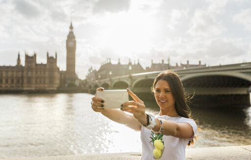 UK, London, schöne Frau macht ein Selfie in der Nähe der Westminster Bridge - MGOF03636