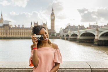 UK, London, schöne Frau, die ein Foto in der Nähe der Westminster Bridge macht - MGOF03641