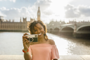 UK, London, schöne Frau, die ein Foto in der Nähe der Westminster Bridge macht - MGOF03642