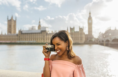 UK, London, schöne Frau, die ein Foto in der Nähe der Westminster Bridge macht - MGOF03643