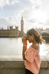 UK, London, schöne Frau, die ein Foto in der Nähe der Westminster Bridge macht - MGOF03644