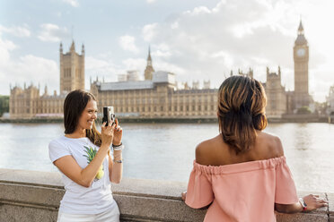 UK, London, Frau mit Freund beim Fotografieren in der Nähe des Palace of Westminster - MGOF03649