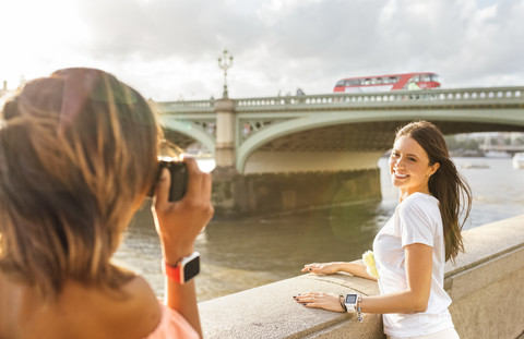 UK, London, woman taking a picture of her friend near Westminster Bridge stock photo