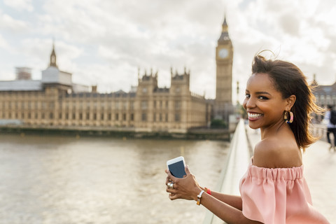 UK, London, Porträt einer lächelnden Frau auf der Westminster Bridge, lizenzfreies Stockfoto