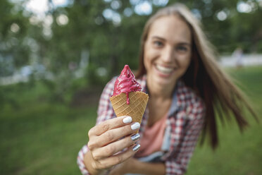 Glückliche junge Frau mit Eiswaffel in der Hand - VPIF00155