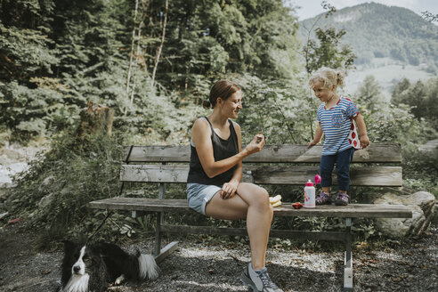 Mutter und Kleinkind mit Hund auf einer Bank im Wald - DWF00296