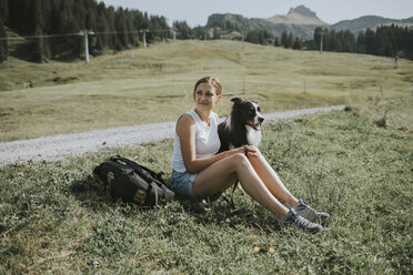 Österreich, Vorarlberg, Mellau, Frau mit Hund bei einem Ausflug in die Berge - DWF00297