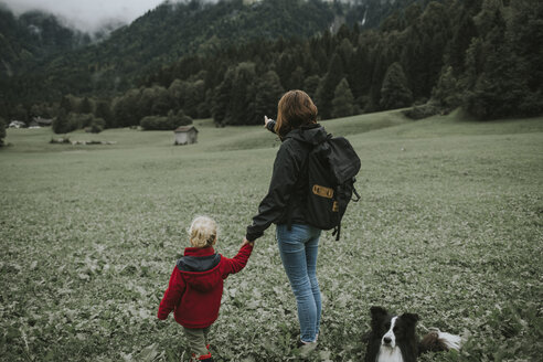 Österreich, Vorarlberg, Mellau, Mutter und Kleinkind mit Hund bei einem Ausflug in die Berge - DWF00298