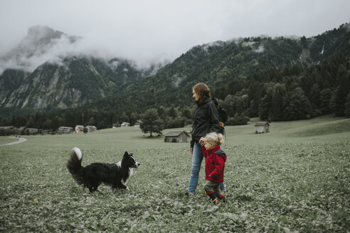 Österreich, Vorarlberg, Mellau, Mutter und Kleinkind mit Hund bei einem Ausflug in die Berge - DWF00300