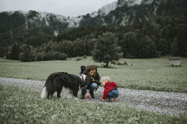 Österreich, Vorarlberg, Mellau, Mutter und Kleinkind mit Hund bei einem Ausflug in die Berge - DWF00303