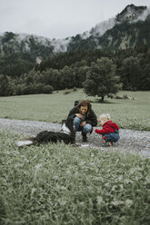 Österreich, Vorarlberg, Mellau, Mutter und Kleinkind mit Hund bei einem Ausflug in die Berge - DWF00304