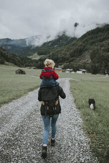 Austria, Vorarlberg, Mellau, mother carrying toddler on shoulders on a trip in the mountains - DWF00316