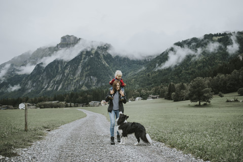 Austria, Vorarlberg, Mellau, mother carrying toddler on shoulders on a trip in the mountains stock photo