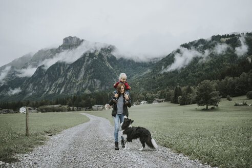 Österreich, Vorarlberg, Mellau, Mutter trägt Kleinkind auf den Schultern bei einem Ausflug in die Berge - DWF00317