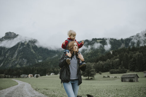 Austria, Vorarlberg, Mellau, mother carrying toddler on shoulders on a trip in the mountains - DWF00318