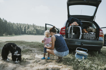 Mutter und Kleinkind mit Hund an einem Auto auf dem Lande - DWF00319