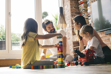 Familie spielt mit Bauklötzen auf dem Boden - JUBF00256