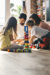 Family playing with building blocks on the floor together - JUBF00258