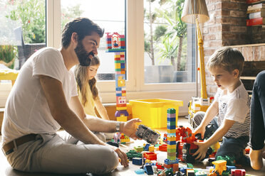 Family playing with building blocks on the floor together - JUBF00259