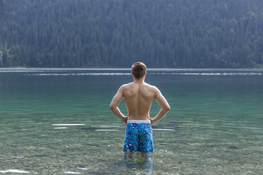 Germany, Bavaria, Eibsee, back view of young man standing in water - TCF05446
