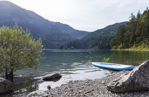 Deutschland, Bayern, Eibsee, Surfbrett am Seeufer, lizenzfreies Stockfoto