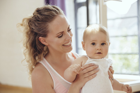 Smiling mother holding her baby stock photo