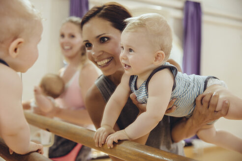 Mutter hält ihr Baby hoch, um im Tanzstudio zu tanzen - MFF04017